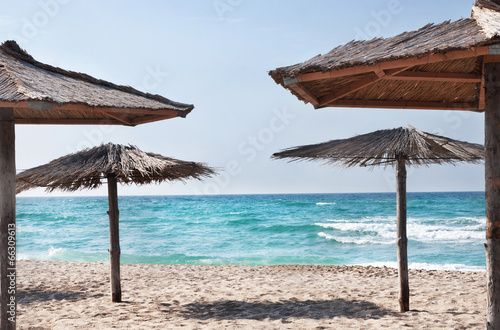 pure tropical sea beach with the straw beach umbrellas