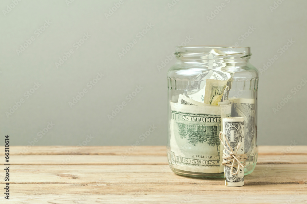 Money in glass jar on wooden table Money in glass jar on wooden table