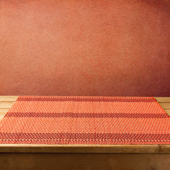 Bamboo tablecloth on wooden table over grunge  red background