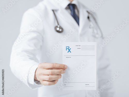 Fotografie male doctor holding rx paper in hand