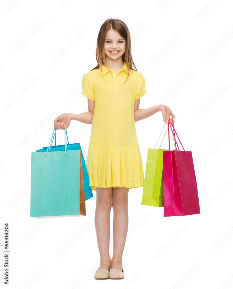 smiling little girl in dress with shopping bags
