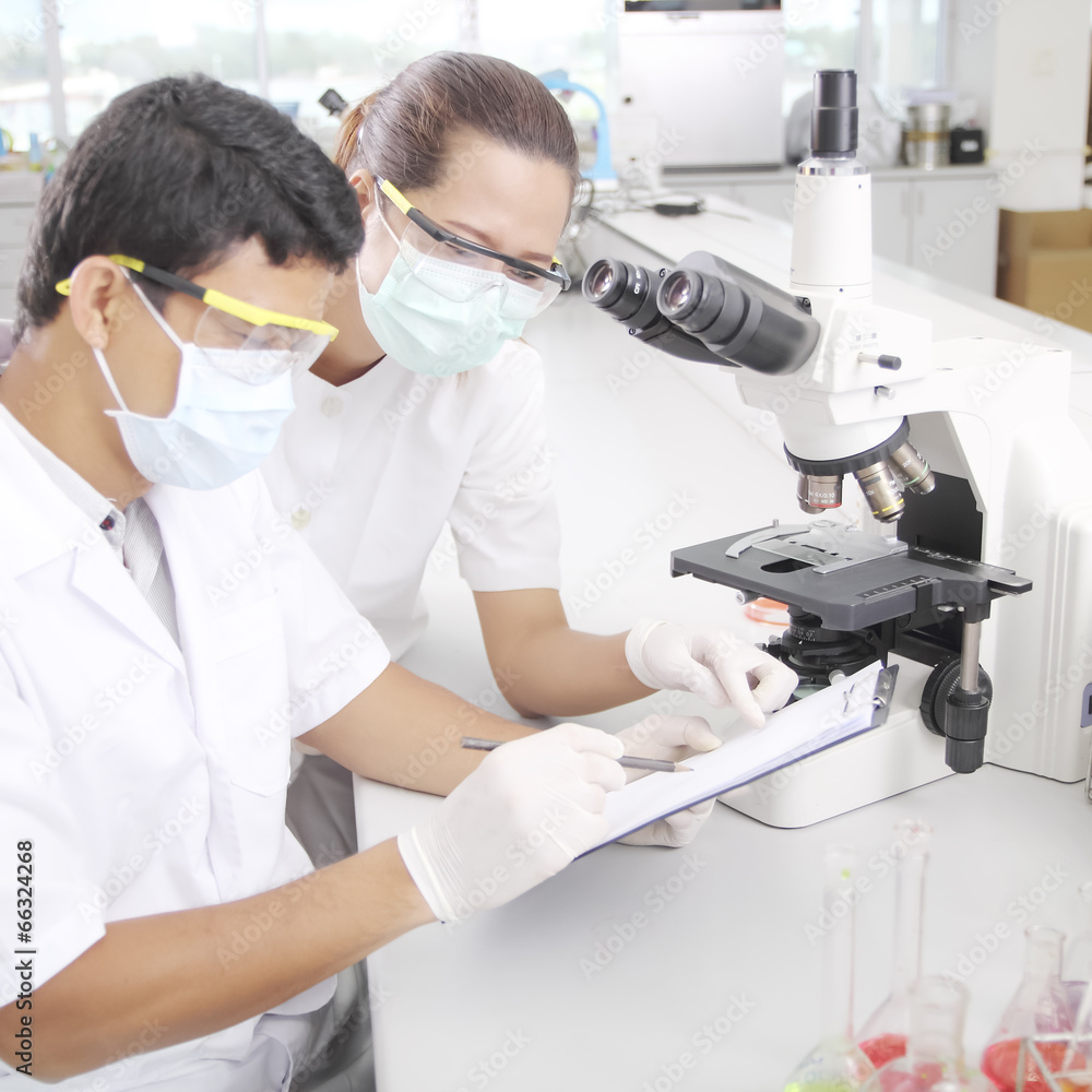Two clinicians discussing medical document in laboratory Two clinicians discussing medical document in laboratory