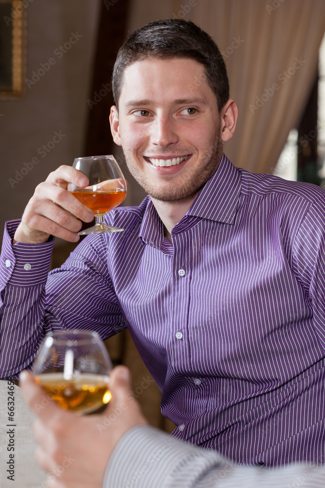 Fototapeta premium Man drinking cognac with friend