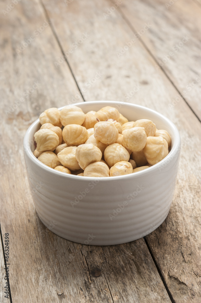 Hazelnuts close up on white bowl Hazelnuts close up on white bowl