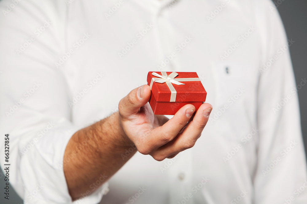 Man gives a present wrapped in red gift paper Man gives a present wrapped in red gift paper