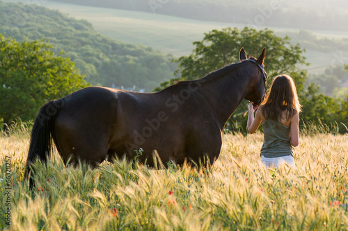 woman and horse training during sunset