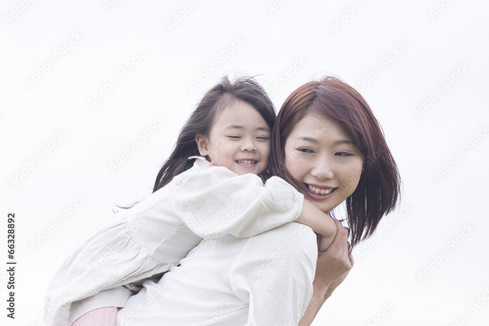 笑顔でおんぶする母と子供 笑顔でおんぶする母と子供