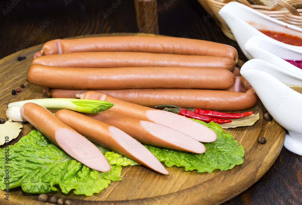 sausages on a wooden plate with vegetables in a restaurant sausages on a wooden plate with vegetables in a restaurant