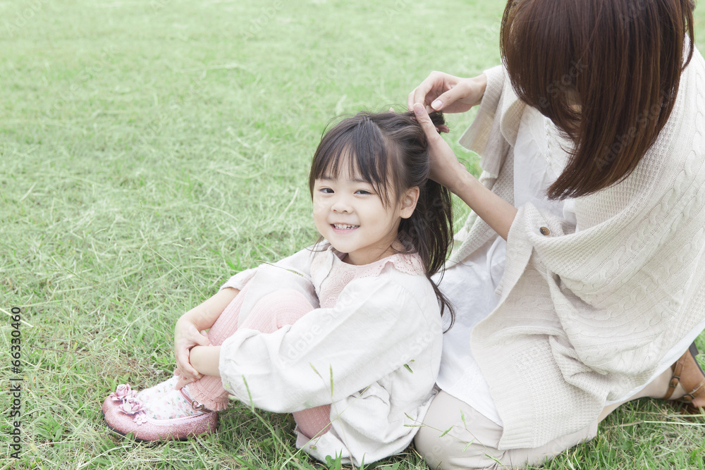芝生で髪を結う母と子 Stock Photo | Adobe Stock