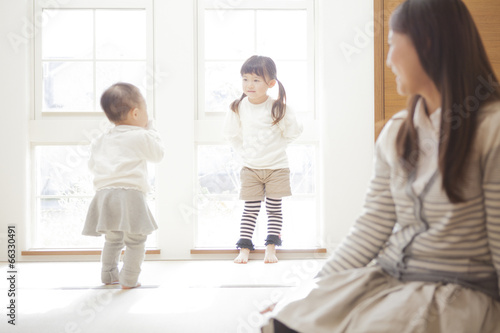 遊ぶ子供達を見つめる母親