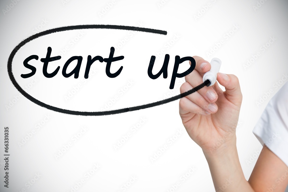 Businesswoman writing the words start up Businesswoman writing the words start up
