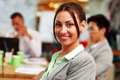 Portrait of a happy businesswoman in front of colleagues