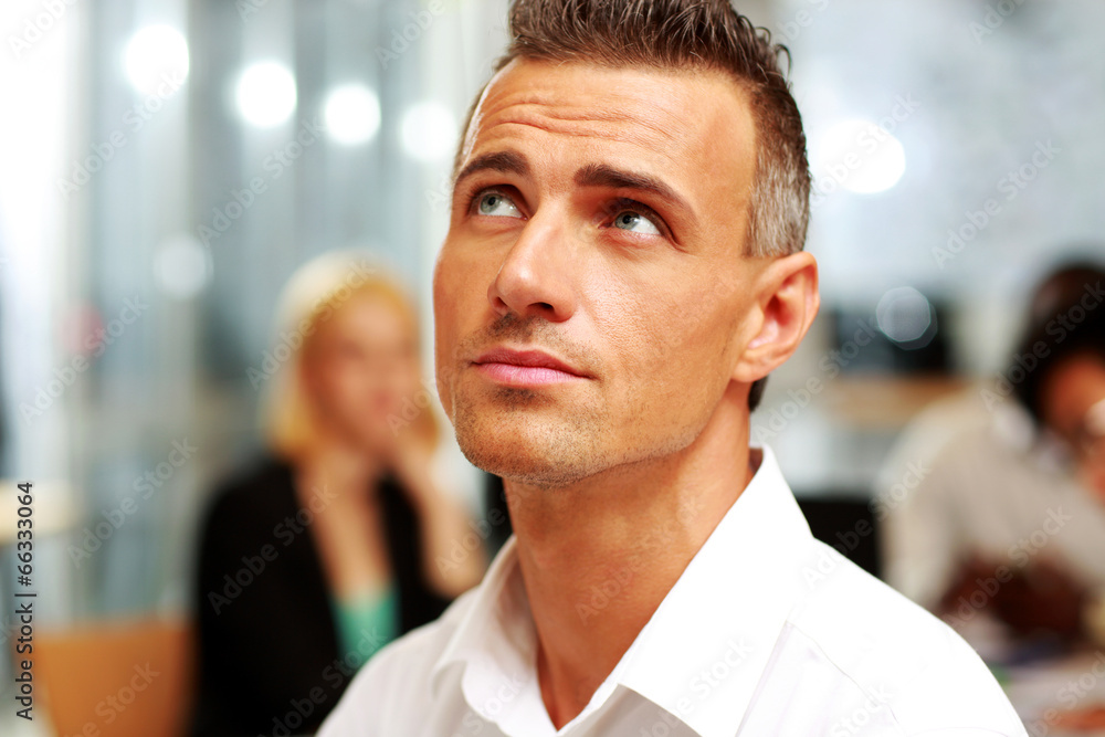 Portrait of a pensive businessman at the office looking up Portrait of a pensive businessman at the office looking up