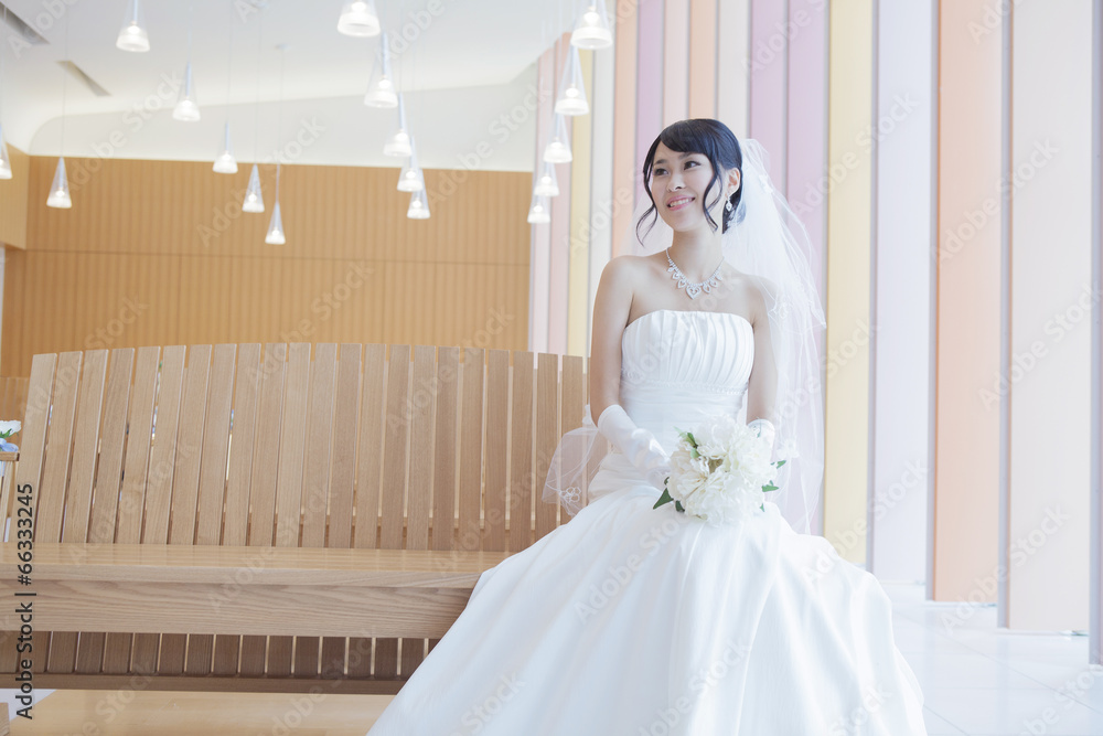 教会で座るブーケを持ったウエディングドレス姿の女性 Stock Photo Adobe Stock