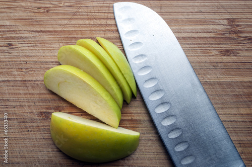 Large knife and apple on a wooden board photo