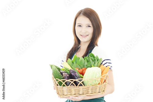 野菜を持つ笑顔の女性