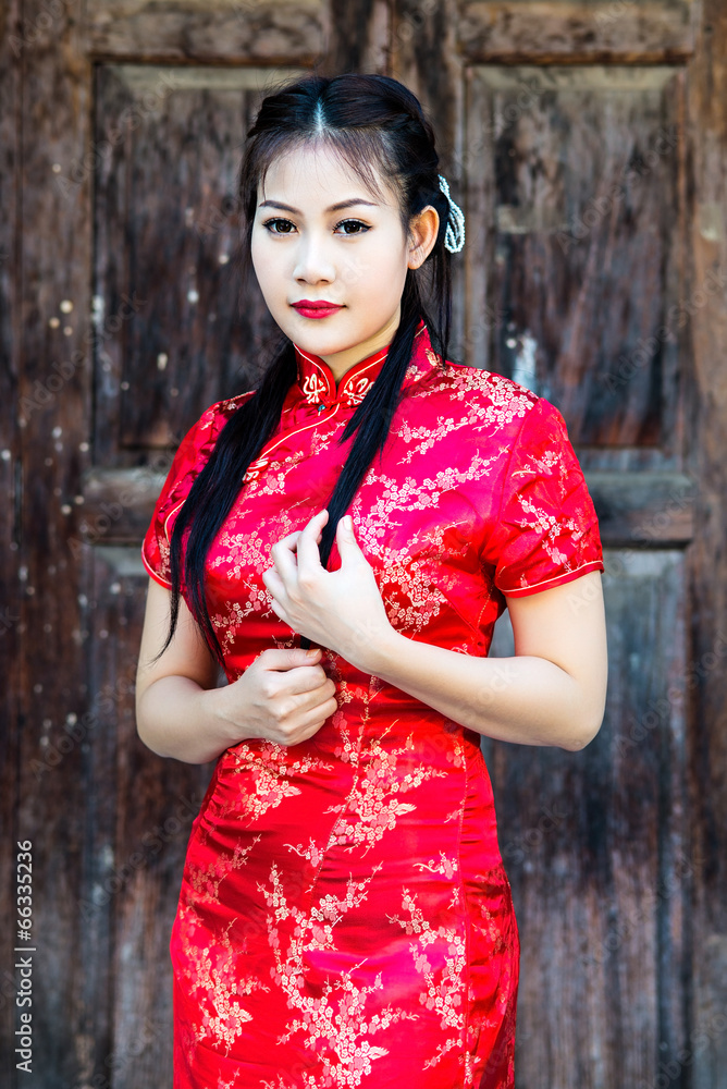 Fototapeta premium Chinese girl in traditional Chinese cheongsam blessing