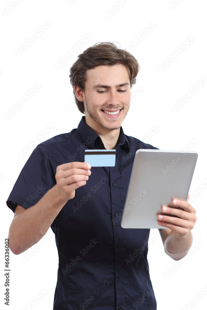 Happy man shopping with a credit card in a tablet Happy man shopping with a credit card in a tablet