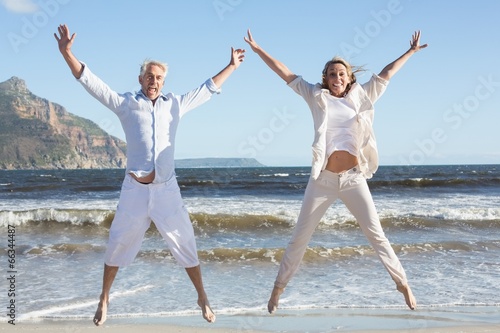 Fotografija Happy couple jumping on the beach together