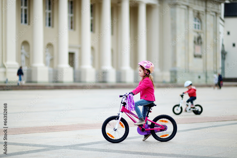 Adorable little girl riding a bike