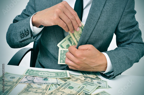 man in suit getting dollar bills in his jacket photo