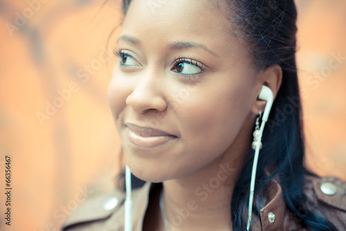 beautiful african young woman listening music earphones