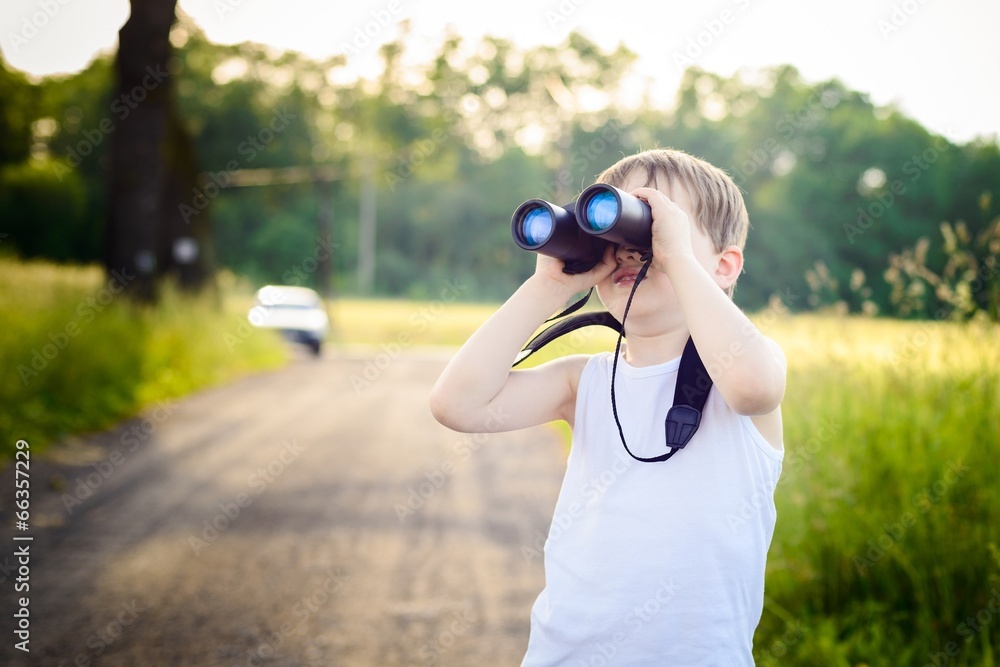 Little boy looking through binoculars