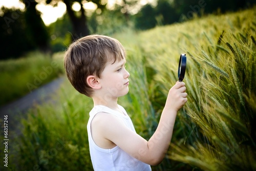 child looks at the grain through a magnifying glass