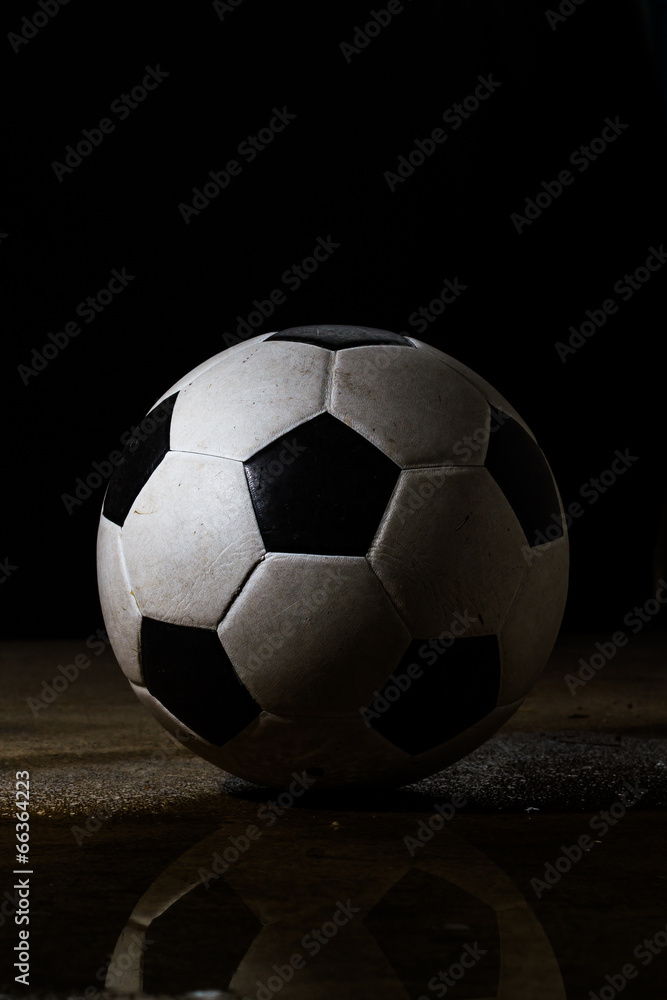 Fototapeta premium Isolated dirty soccer ball on black bavkground