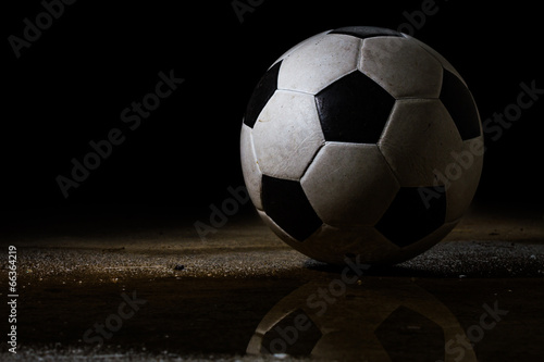 Isolated dirty soccer ball on black bavkground