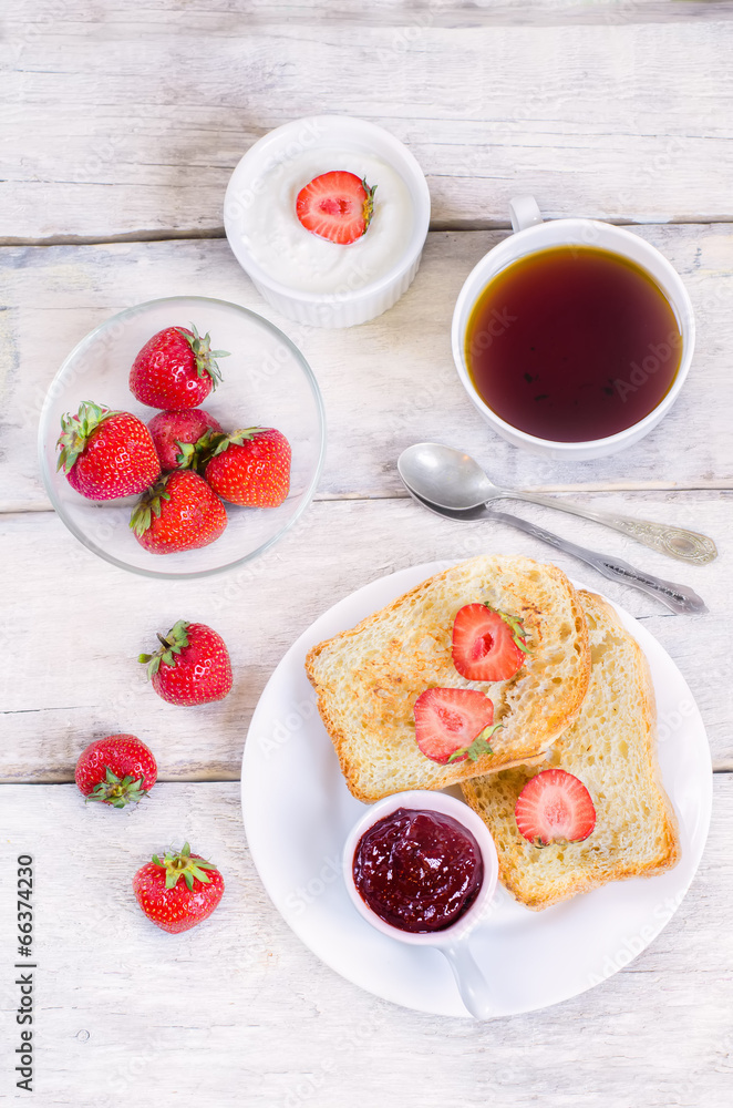 breakfast with fresh toasts, strawberries and strawberry jam
