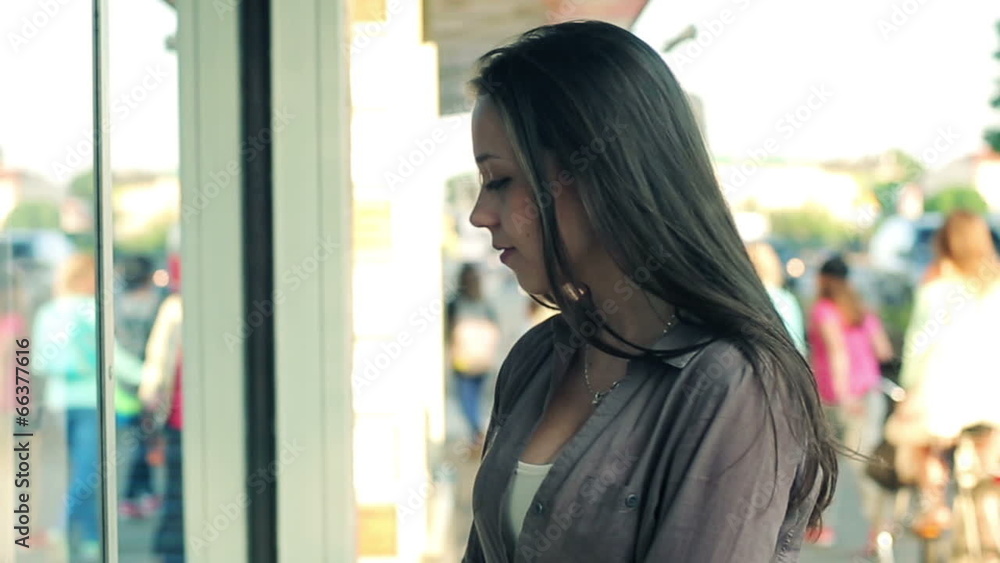 Beautiful young woman looking at shop window in the city Beautiful young woman looking at shop window in the city