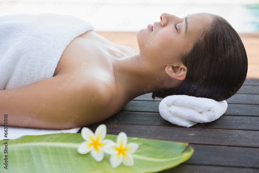 Peaceful brunette lying with eyes closed on a towel Peaceful brunette lying with eyes closed on a towel