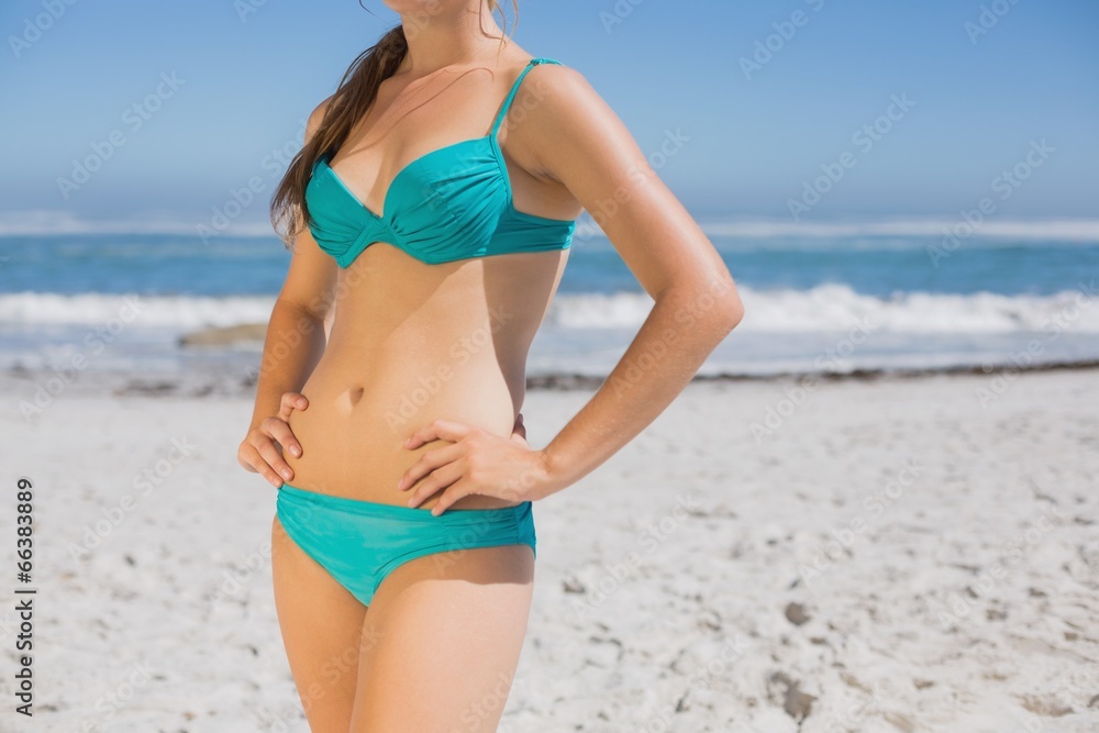 Mid section of fit woman in bikini on the beach Mid section of fit woman in bikini on the beach