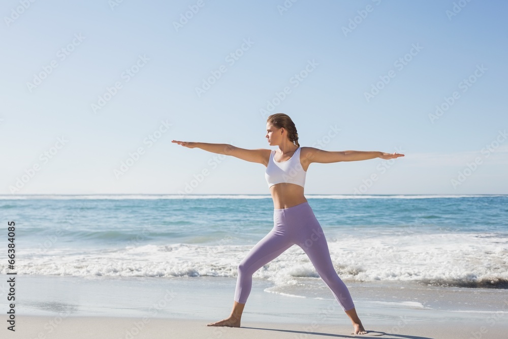 Sporty blonde in warrior pose on the beach Sporty blonde in warrior pose on the beach