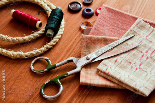 Close-up sewing tools on wooden background, vintage style