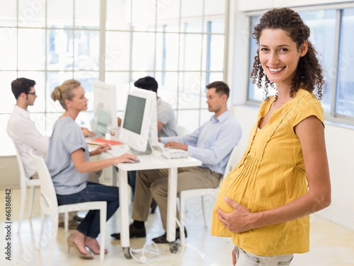 Casual pregnant businesswoman smiling at camera