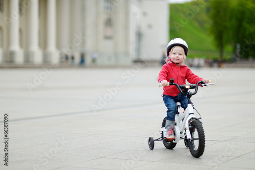 Adorable toddler girl riding her bike © MNStudio
