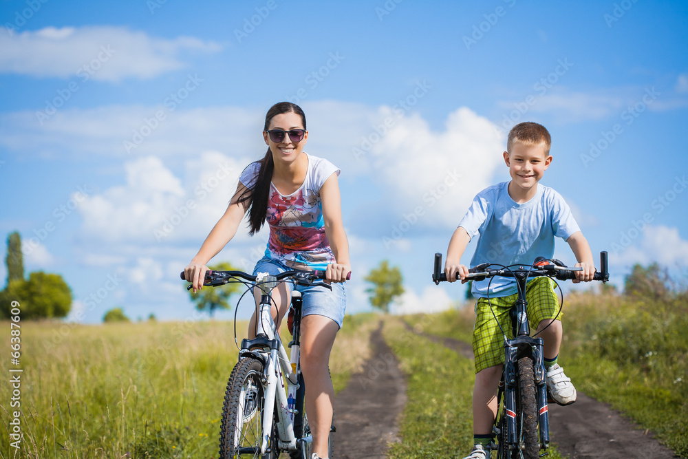 Happy family. mother and son riding  in the field