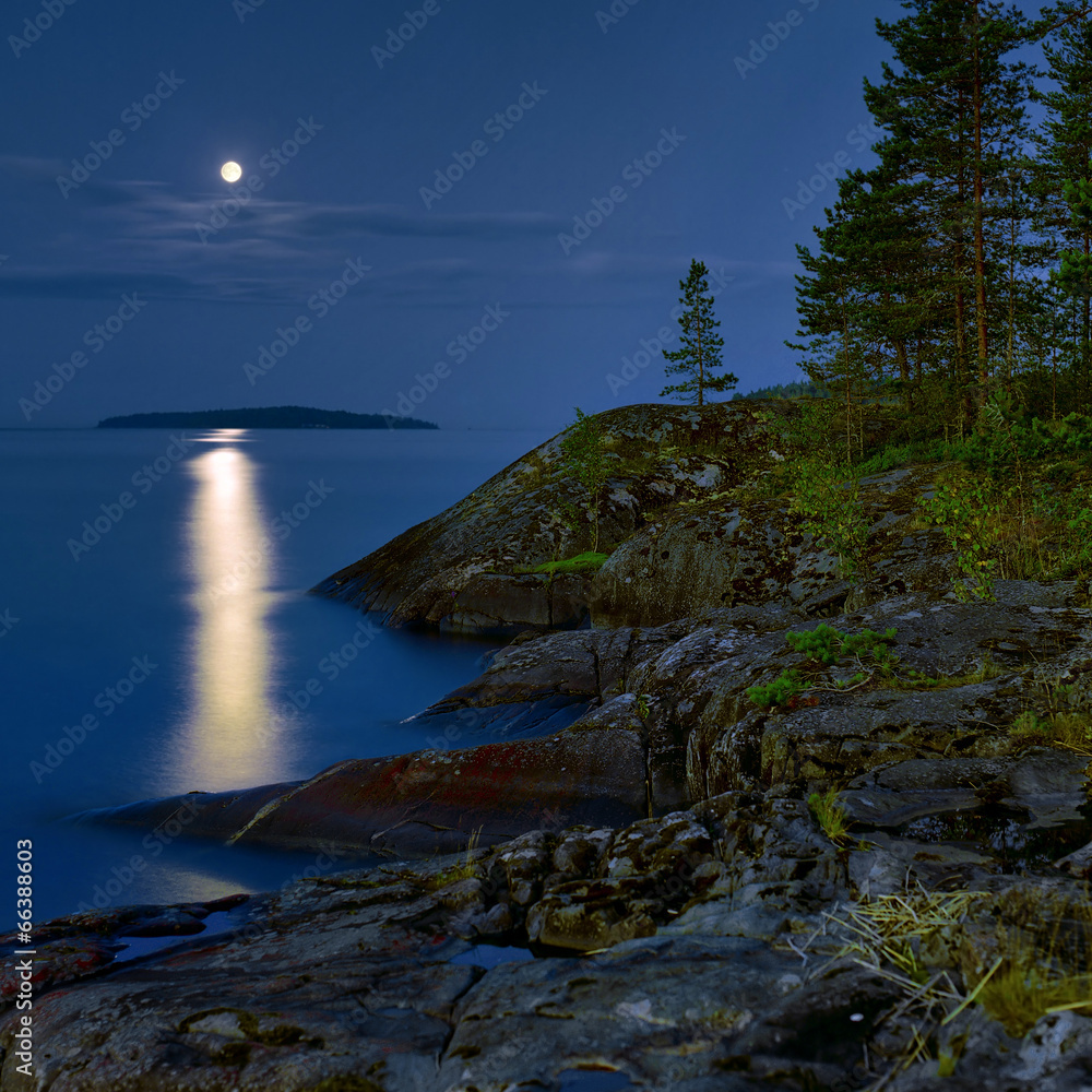 Obraz premium Moonlit night at stony shore of Ladoga lake