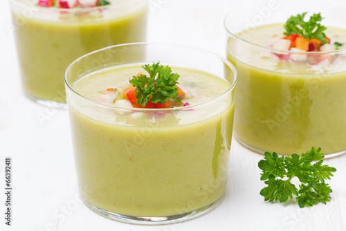green soup with fresh vegetables in glasses, close-up