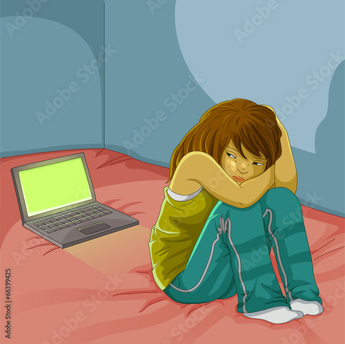 sad girl sitting alone next to her open laptop