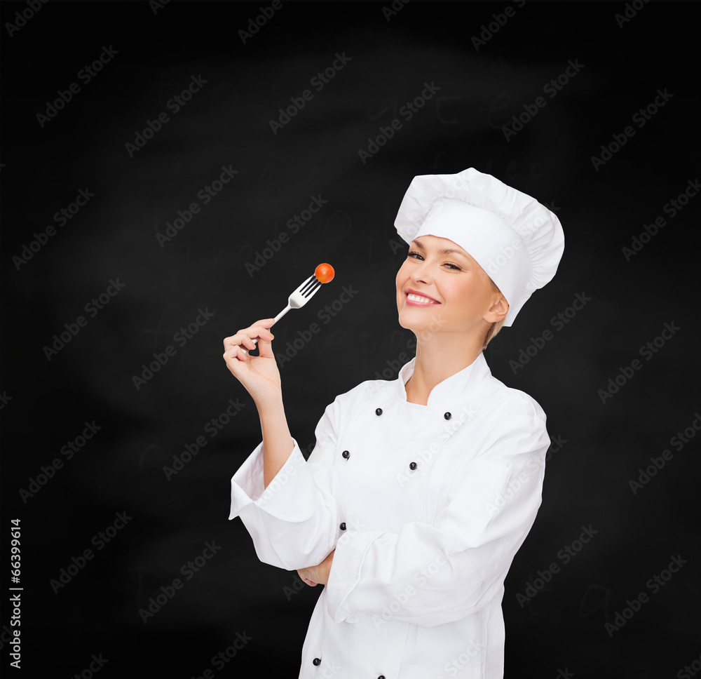 smiling female chef with fork and tomato smiling female chef with fork and tomato
