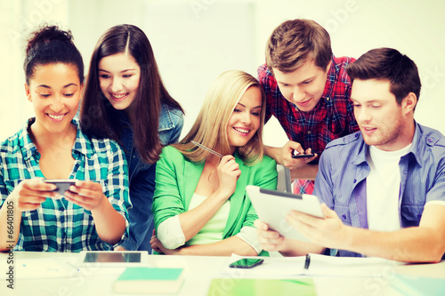 students looking at smartphones and tablet pc