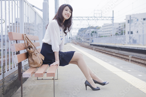 駅のベンチに座る女性 photo