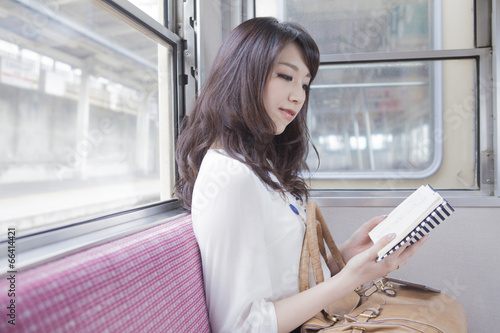 電車で本を読む女性 photo