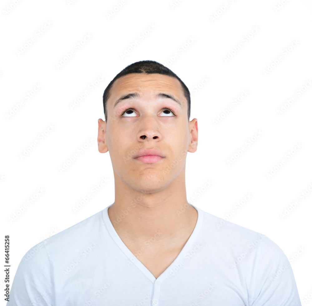 Portrait of young man looking up against white background