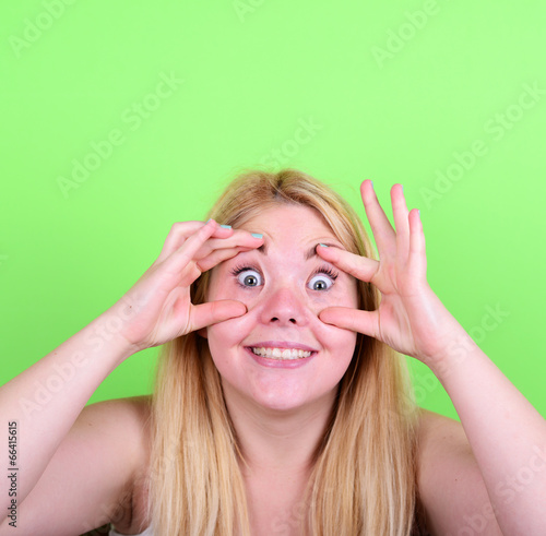 Portrait of girl with funny face against green background photo