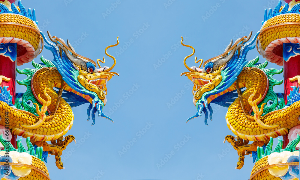 Fototapeta premium Double golden dragon statue on blue sky background