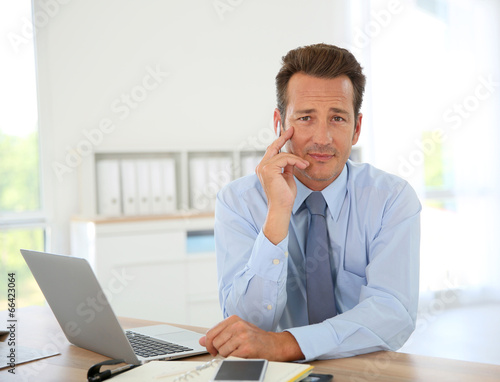 Handsome businessman in office working on laptop